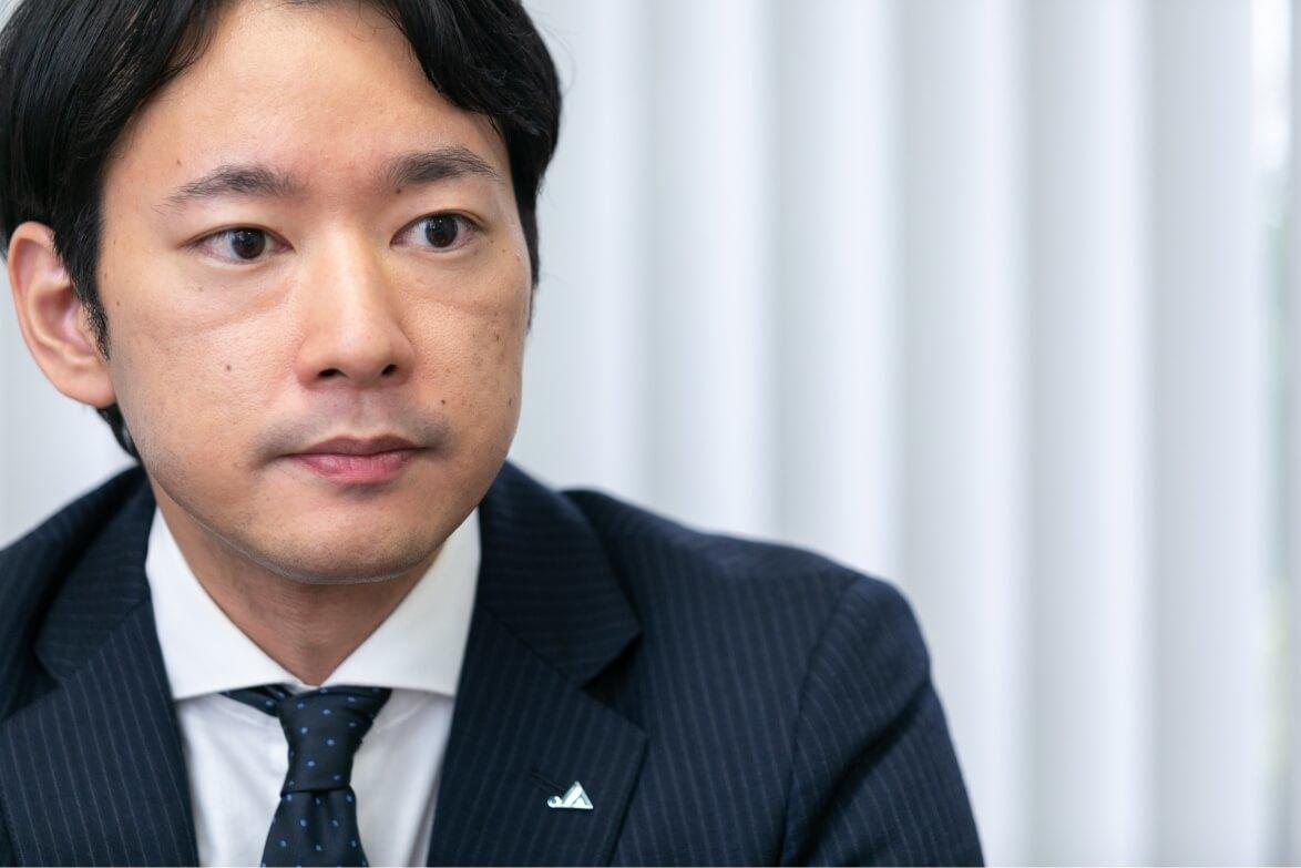 インタビューに答える長野県信連法人融資の男性職員の正面顔