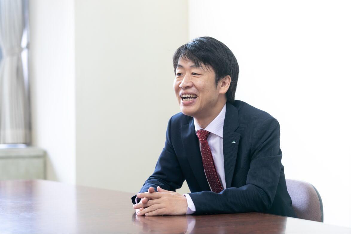 笑顔でインタビューに答える長野県信連ライフサポート推進の男性職員の横顔