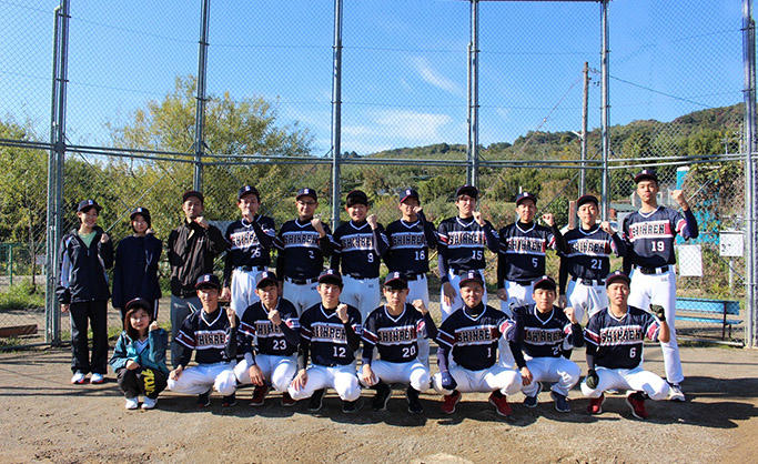長野県信連の野球部16名とマネージャー3名が左手でガッツポーズをしている集合写真