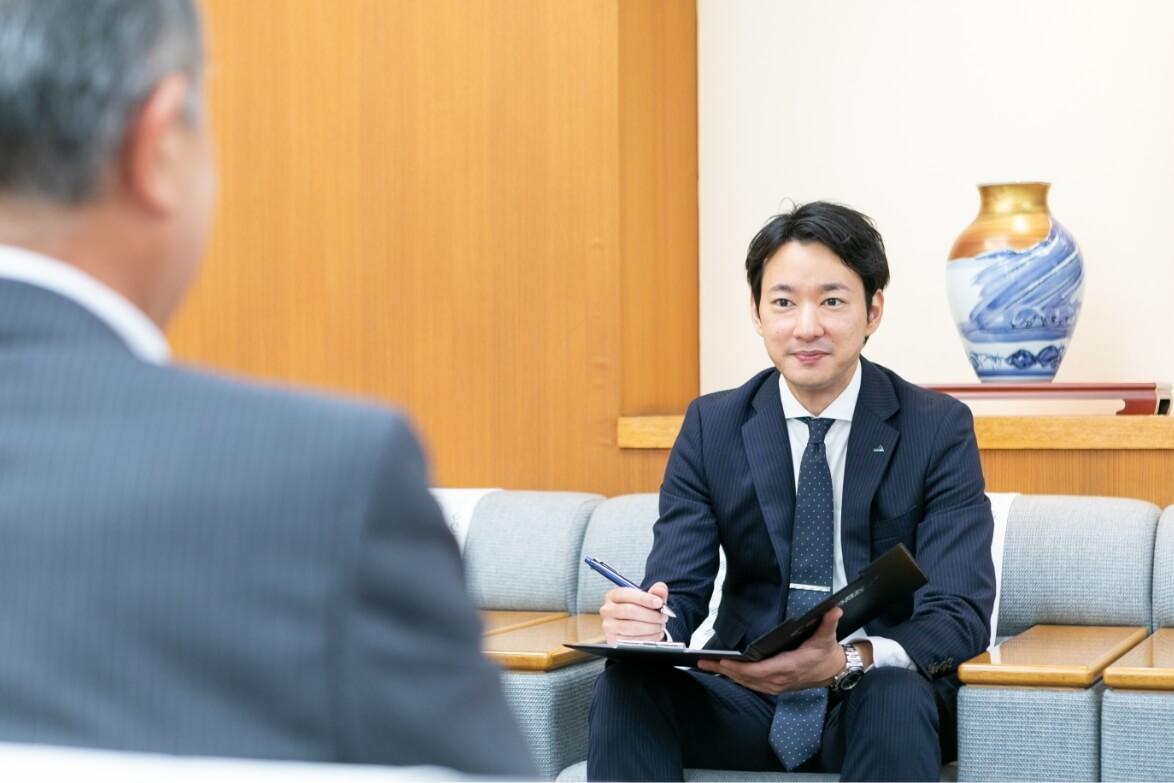 応接室で商談をする長野県信連法人融資の男性職員