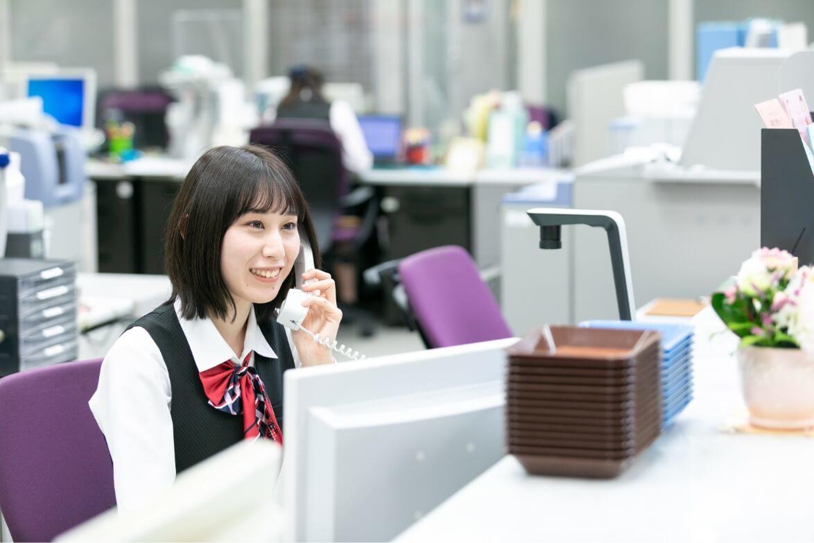 窓口に座り電話応対をする長野県信連貯金為替の女性職員