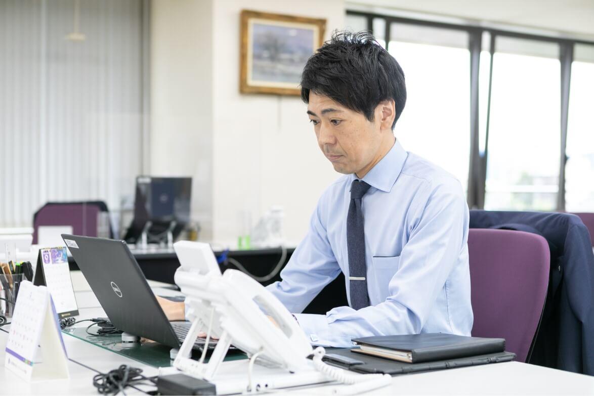 デスクでパソコン作業をする長野県信連アグリビジネス推進の男性職員